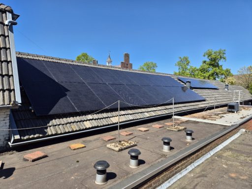 Zonnepanelen op een dak onder een heldere blauwe lucht.